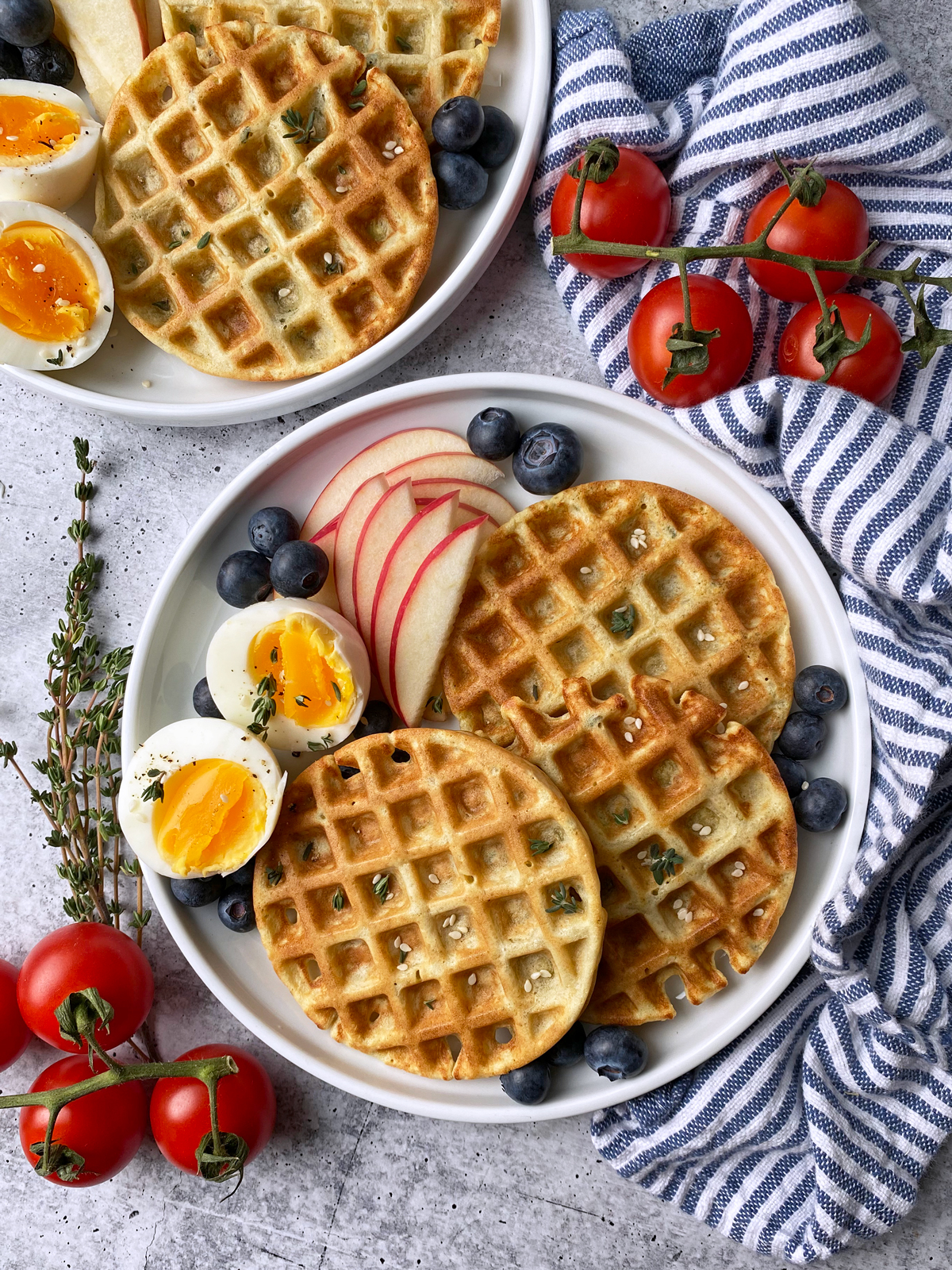 sweet potato waffles with hard boiled egg, apple slices and blueberries on the side