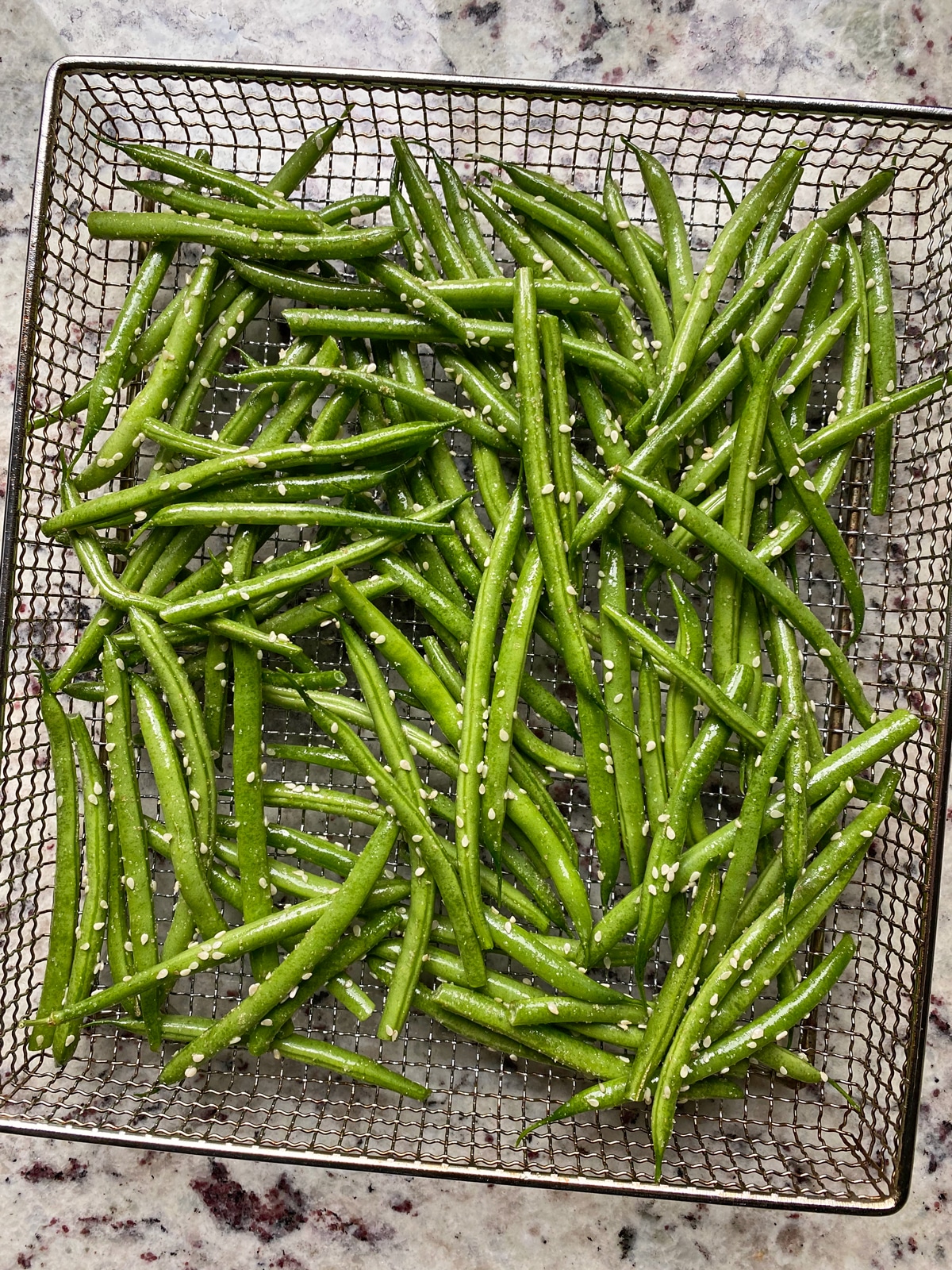 uncooked green beans in air fryer basket