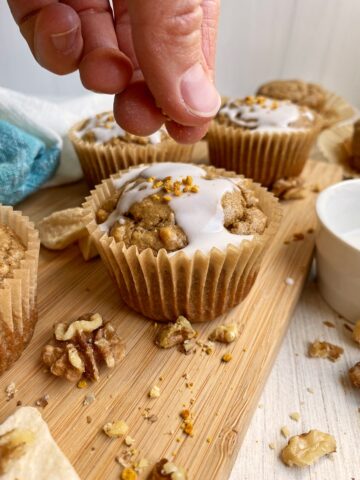 sprinkling bee pollen on iced muffins