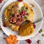 paleo mug cake topped with raspberries, pumpkin seeds and chocolate chips