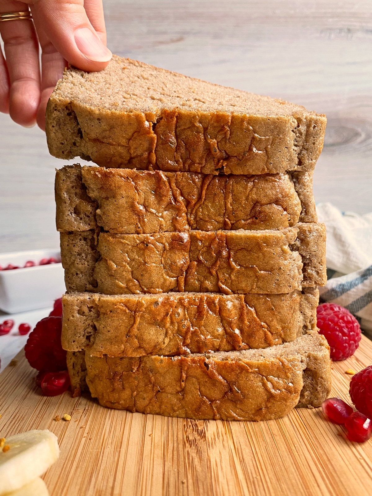 hand grabbing a slice from a stack of bread