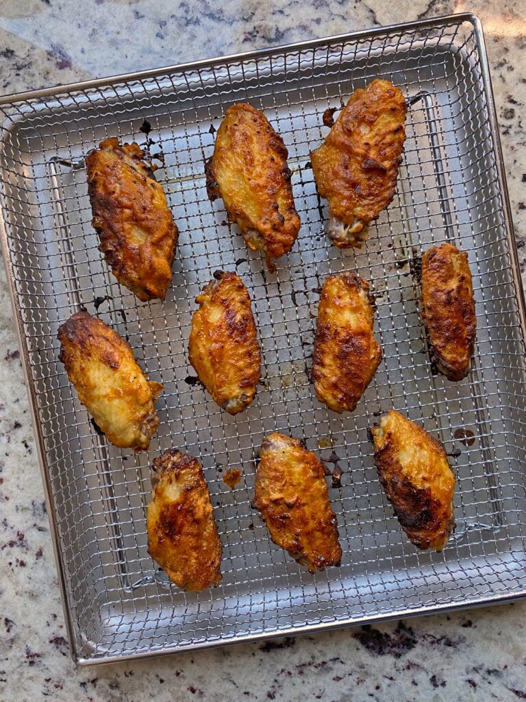 cooked chicken wings on air fryer wire basket