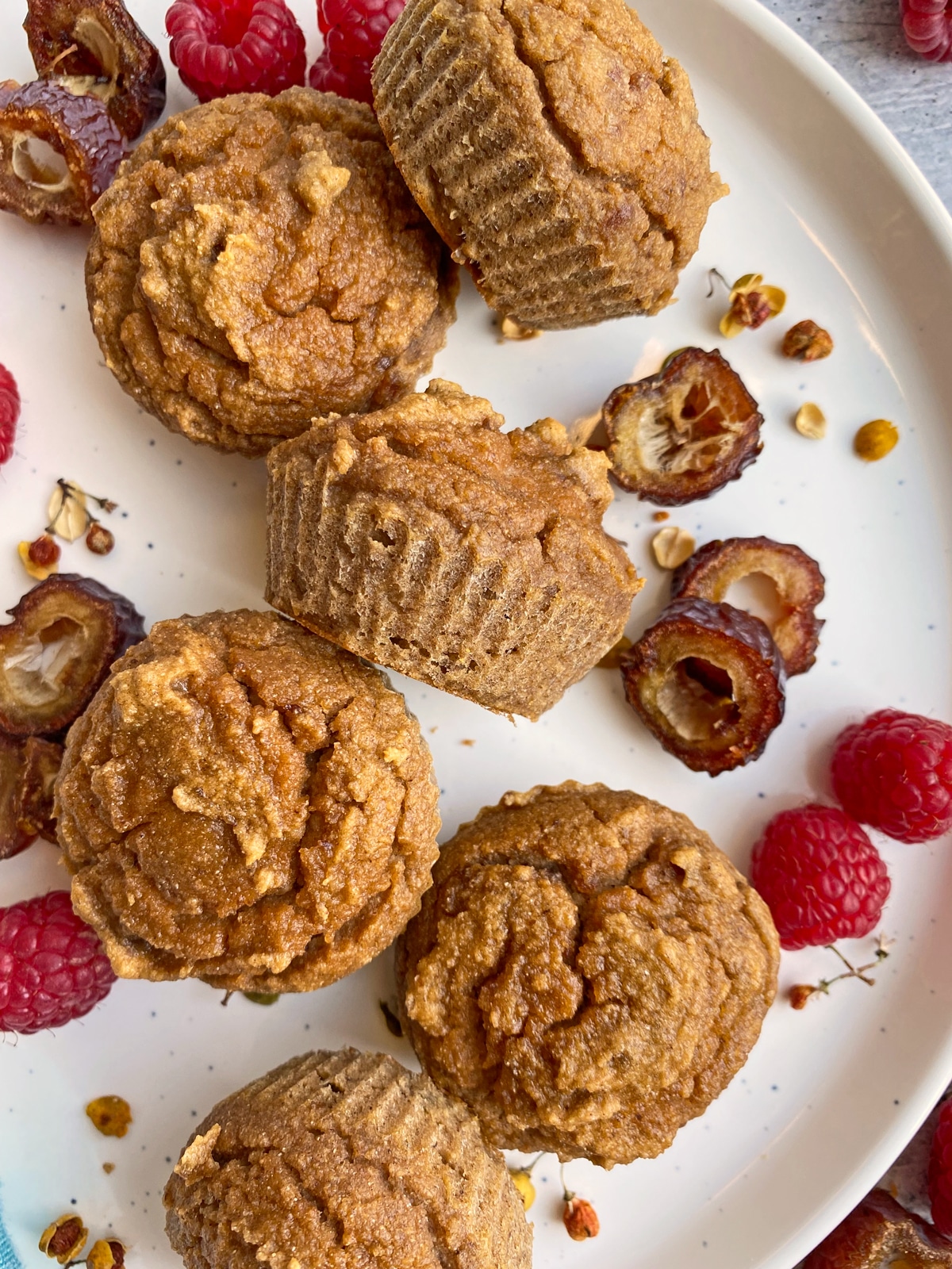 muffins on plate decorated with dates and raspberries