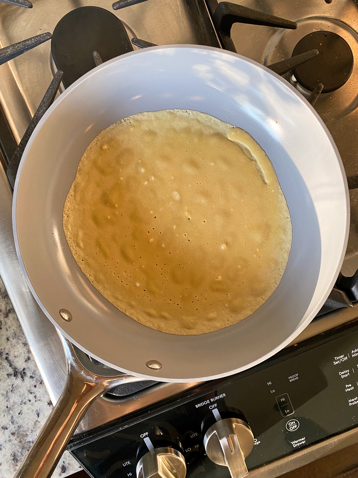 cooking crepe on ceramic frying pan
