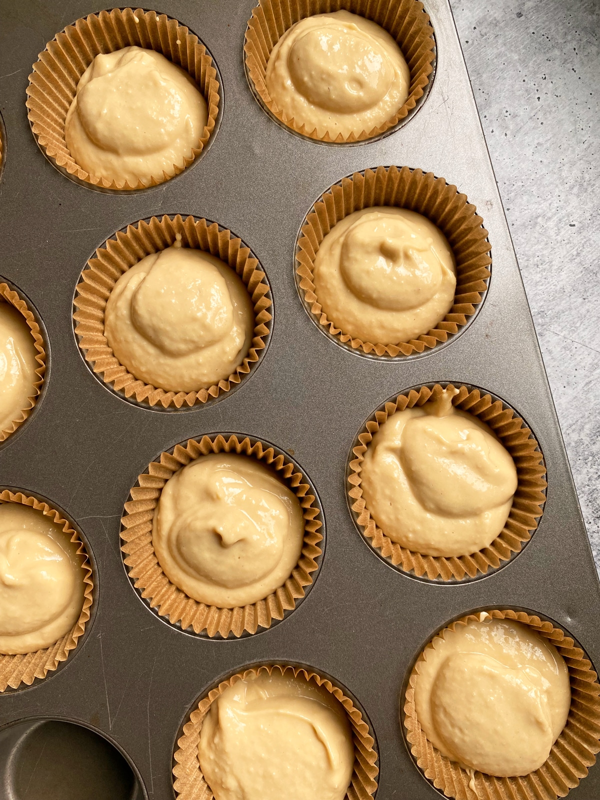 Unbaked muffins in lined muffin pan.