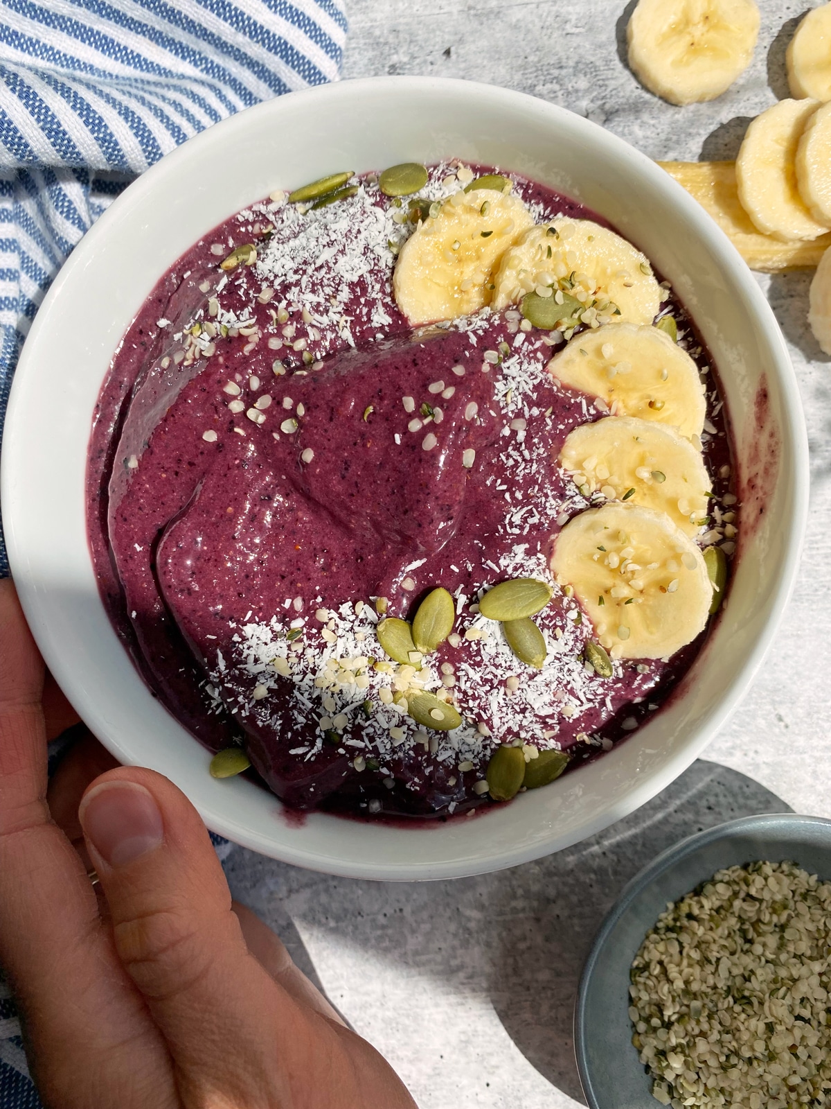 paleo beet smoothie topped with bananas, ccoconut, hemp hearts and pumpkin seeds