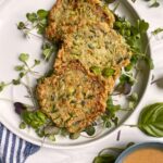 healthy zucchini cakes on plate with microgreens