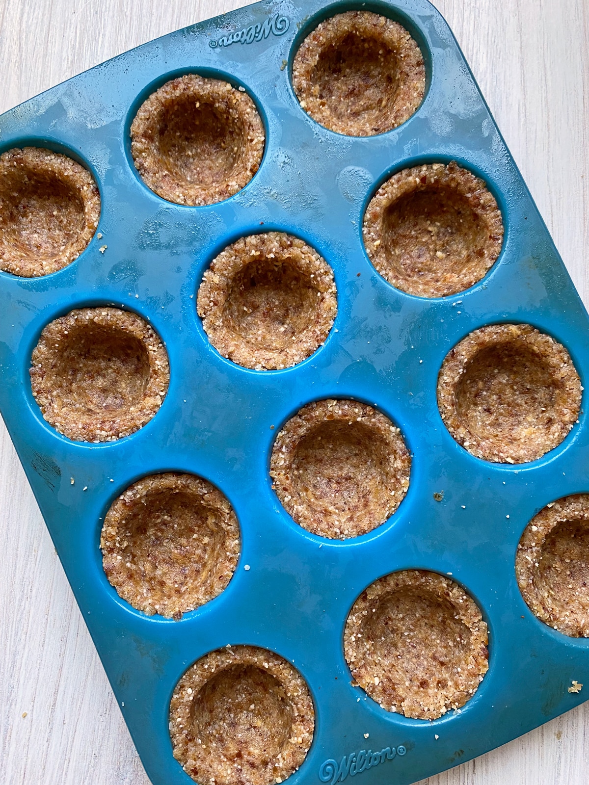 making the hazelnut crust in a mini silicone muffin pan