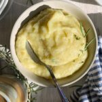 bowl of paleo cauliflower mashed potatoes with a spoon in it