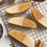 gluten free biscotti dipped in white chocolate on wire cooling rack