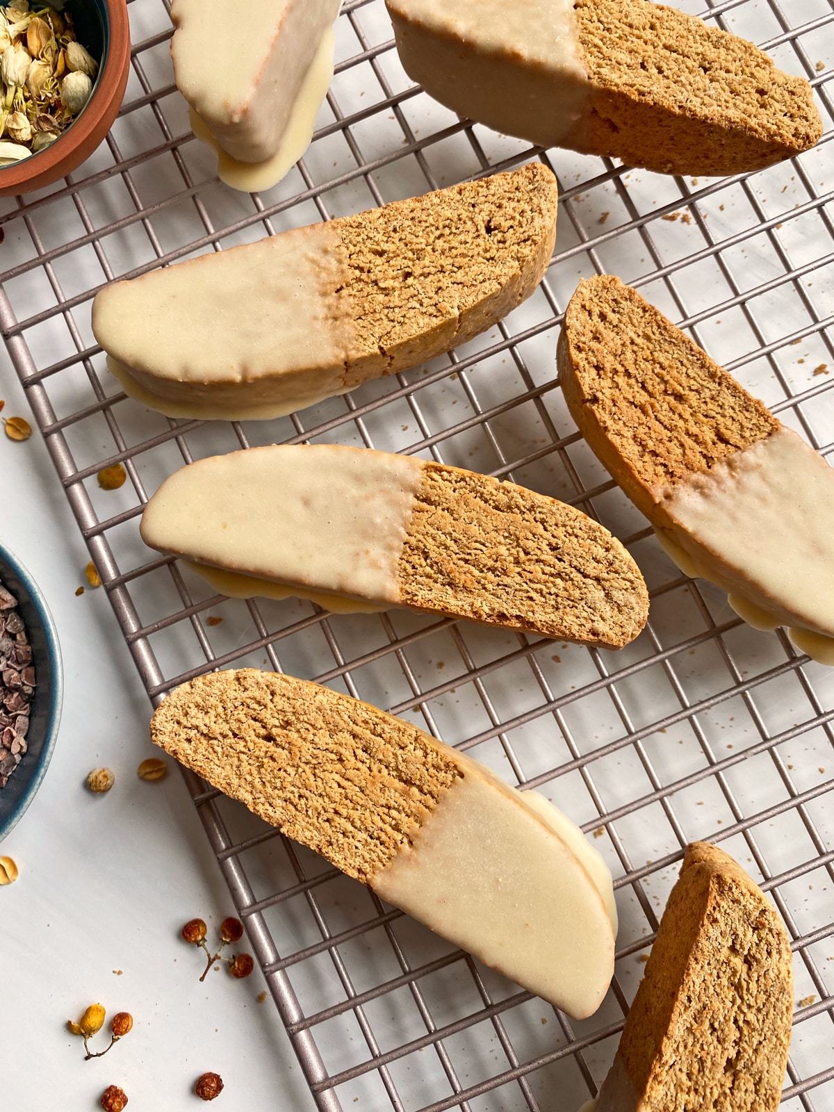 gluten free biscotti dipped in white chocolate on wire cooling rack