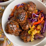 close up of meatballs in bowl with sauteed veggies