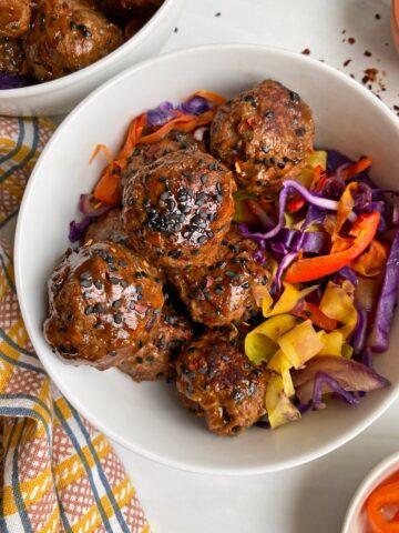 close up of meatballs in bowl with sauteed veggies