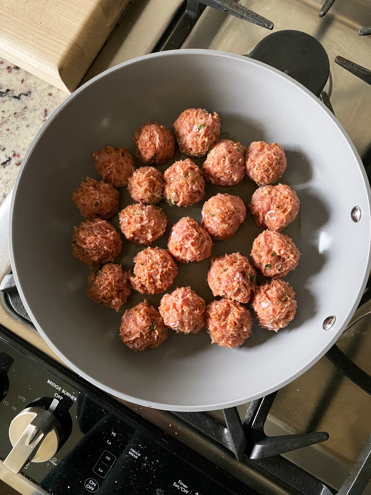 cooking turkey meatballs on the stovetop in a ceramic frying pan