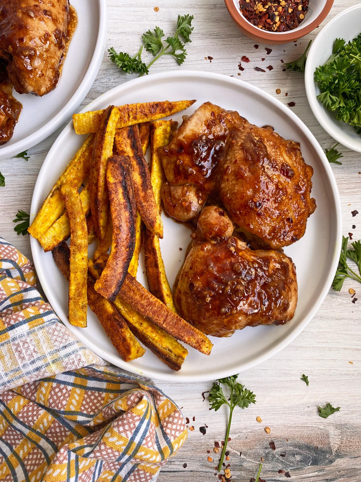 chicken thighs on plate with baked plantain fries