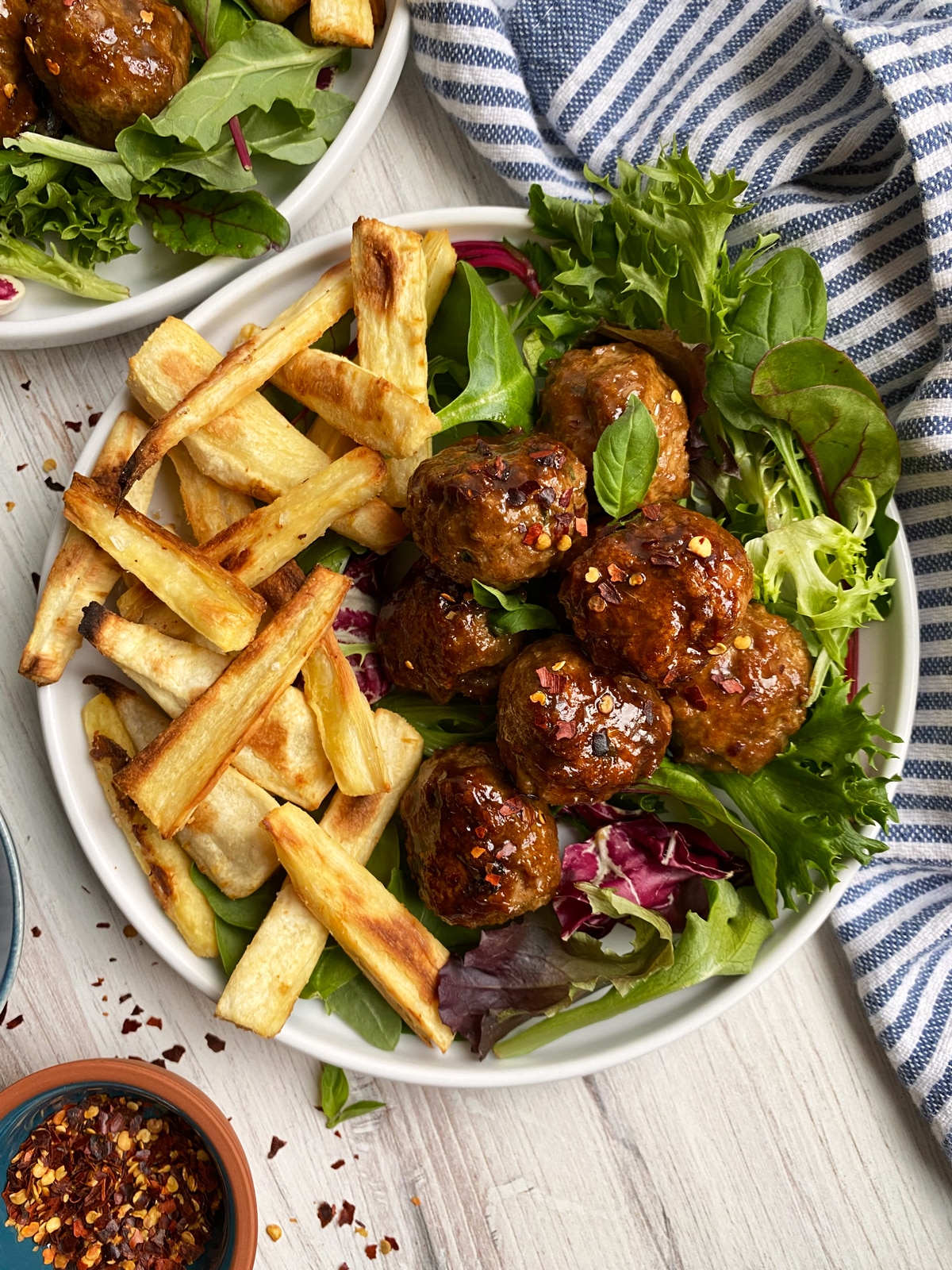 paleo turkey meatballs plated with spring mix lettuce and parsnip fries