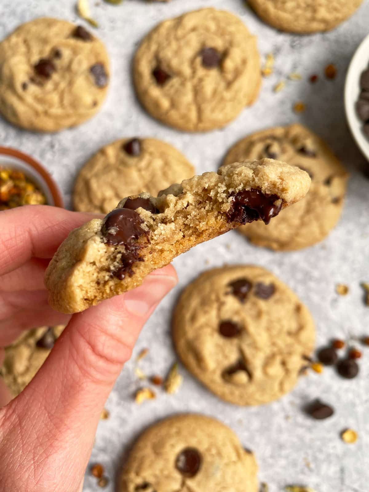 holding a cookie with a bite out of it to show the inside texture