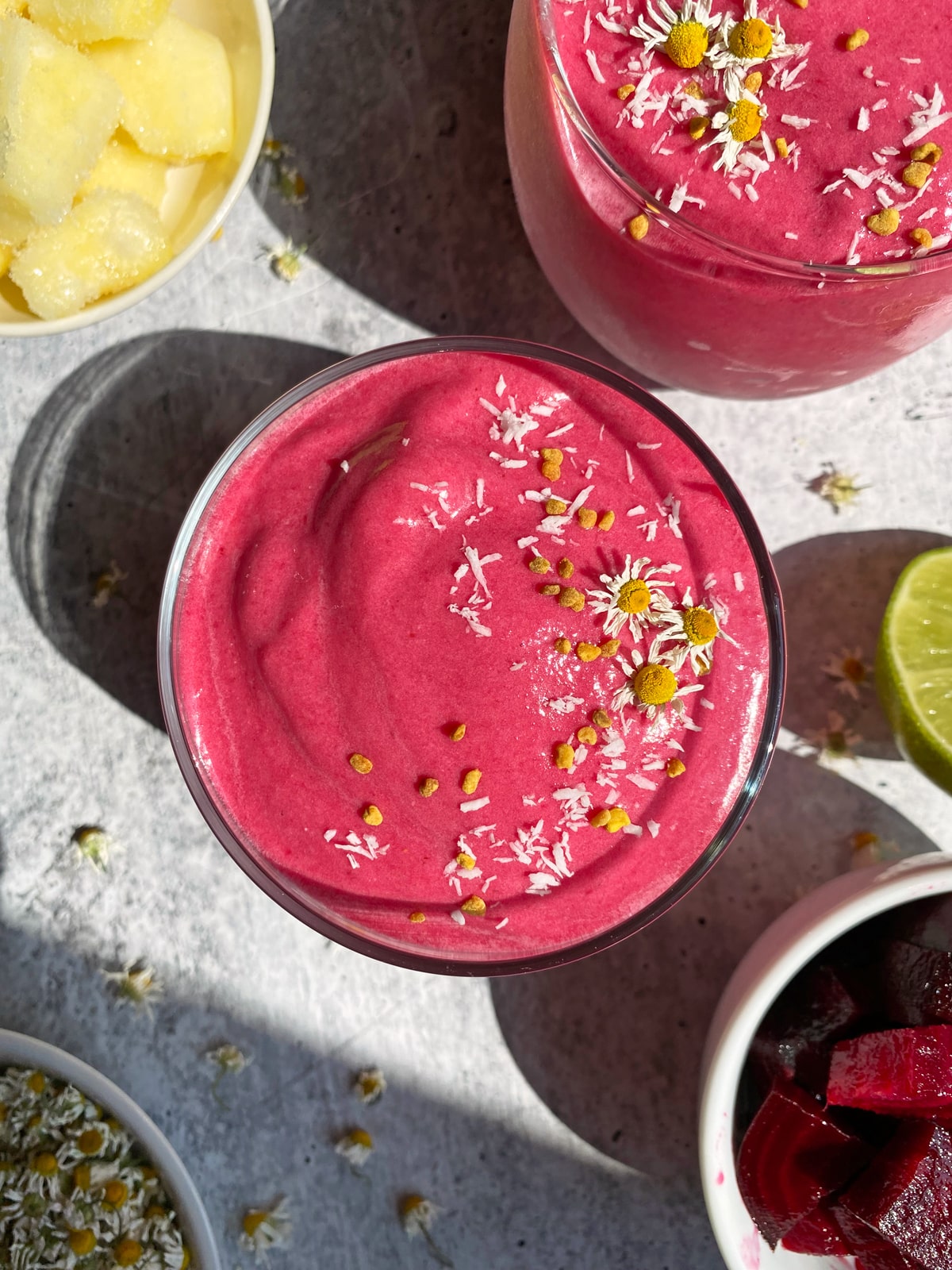 pineapple beet smoothie topped with bee pollen and shredded coconut