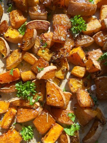 Baked paleo butternut squash topped with flaked salt and parsley.