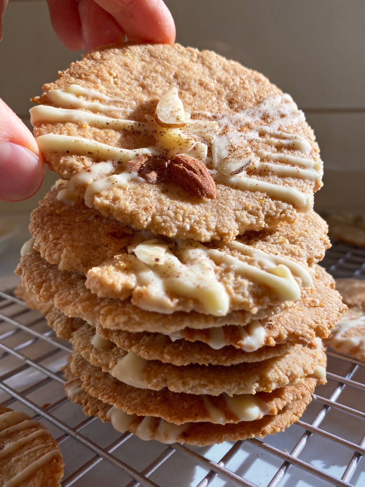 Grabbing the top cookie from a stack of lemon ginger cookies.
