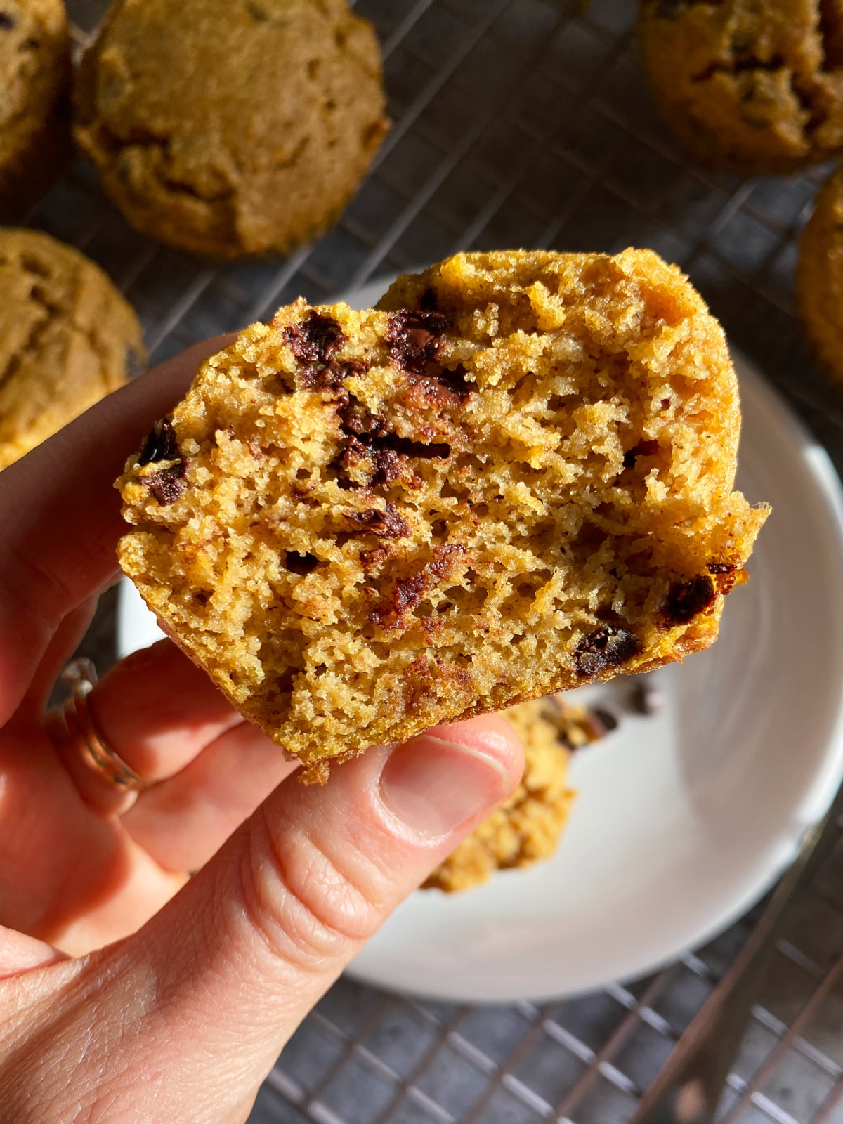 Holding a muffin that's been cut in half to show the inside texture.