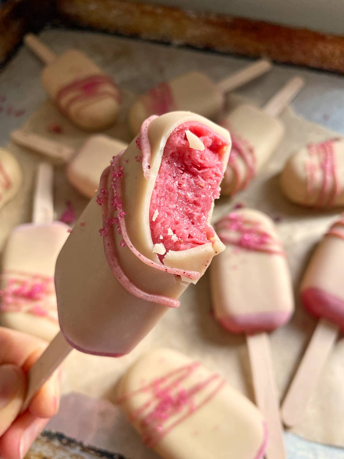 Bite of a strawberry frozen yogurt bar to show the inside texture.