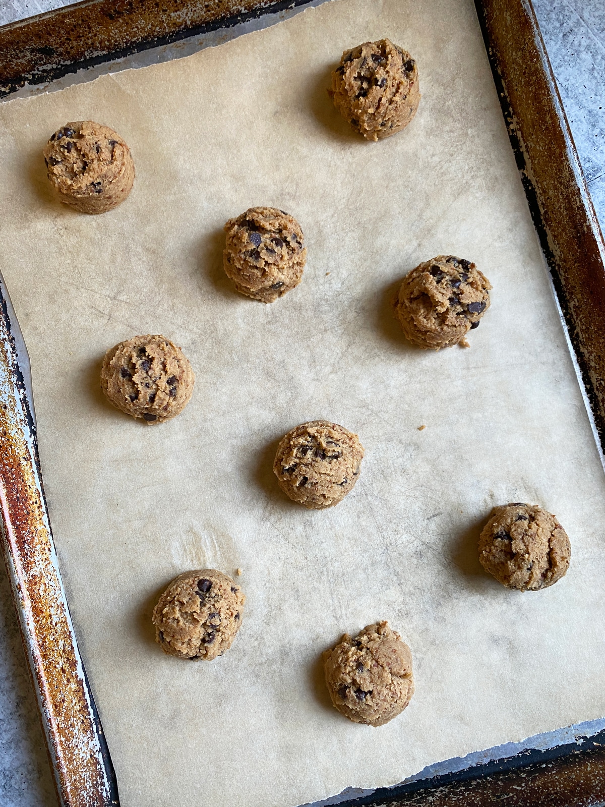Cookie dough scooped onto a lined baking sheet.
