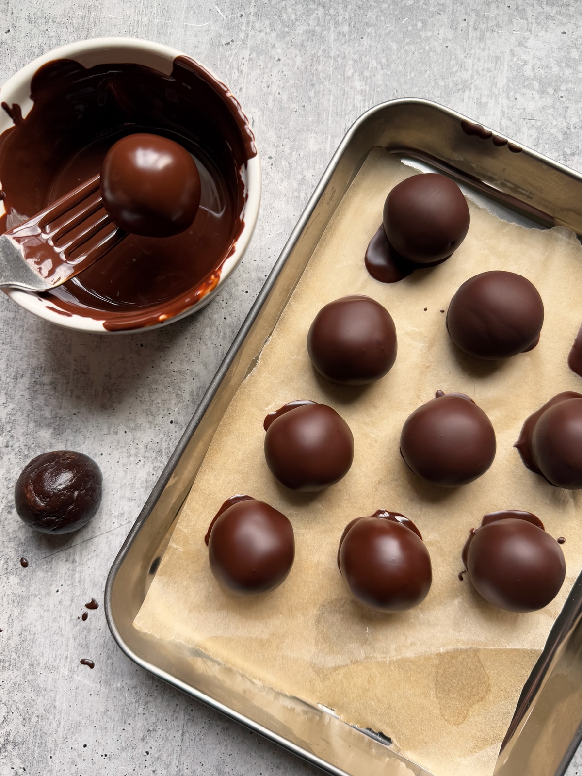 Dipping the balls in dark chocolate.