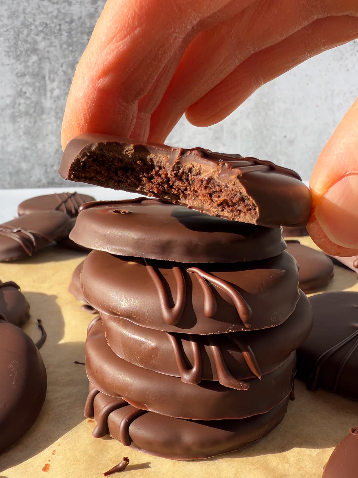 Grabbing a cookie with a bite out of it from a stack of cookies.