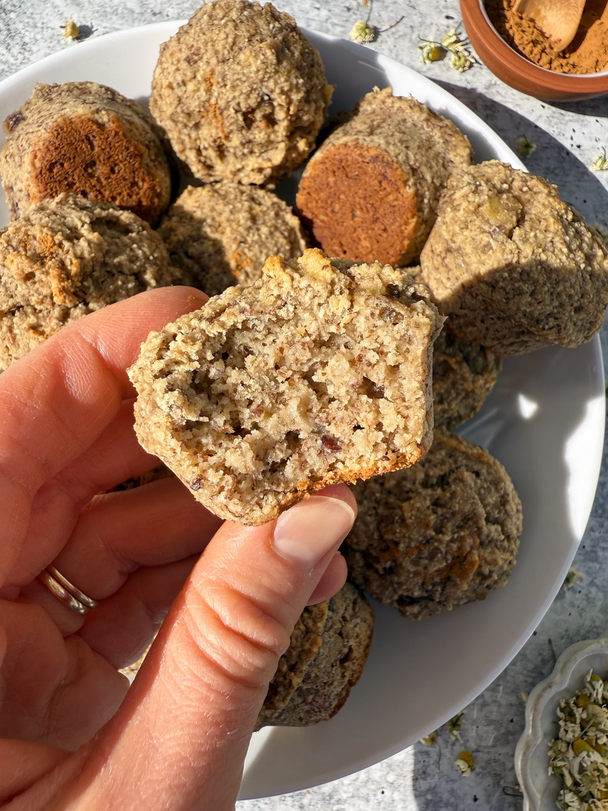 Holding a muffin with a bite out of it.