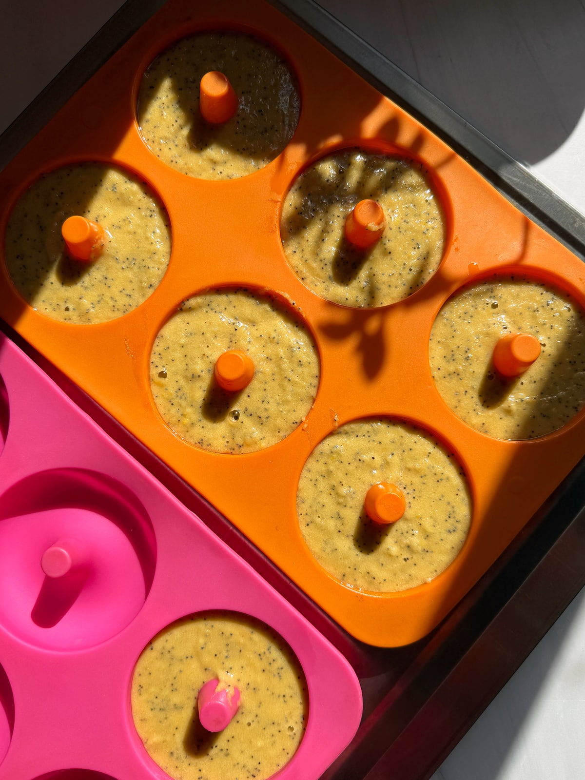 Batter in greased silicone donut molds.