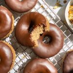 Healthy banana protein donuts on wire cooling rack.