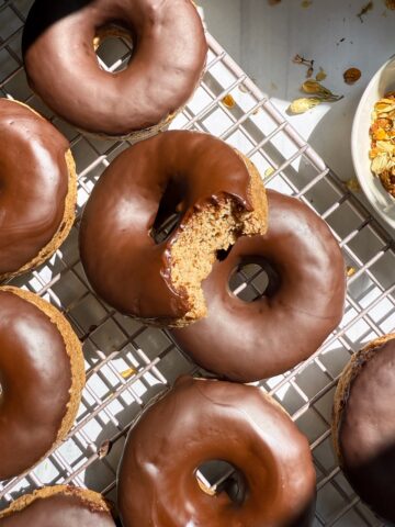 Healthy banana protein donuts on wire cooling rack.