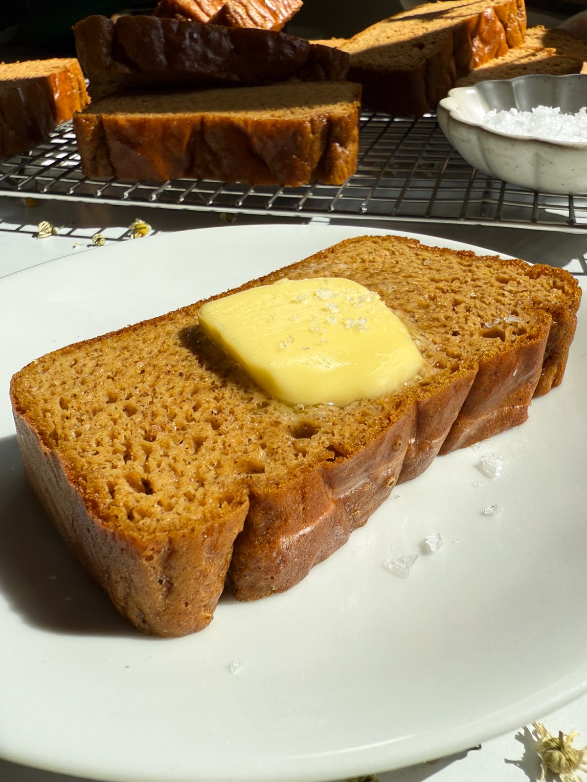 Slice of bread topped with butter and flaked salt.