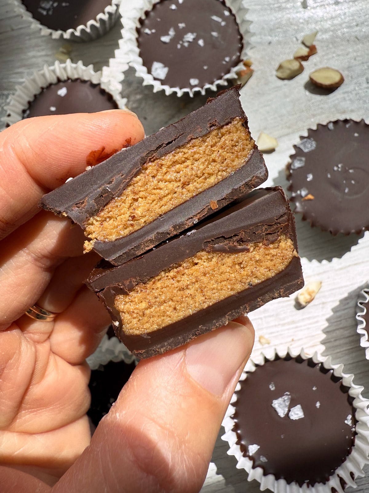 Holding an almond butter cup that's been cut in half.
