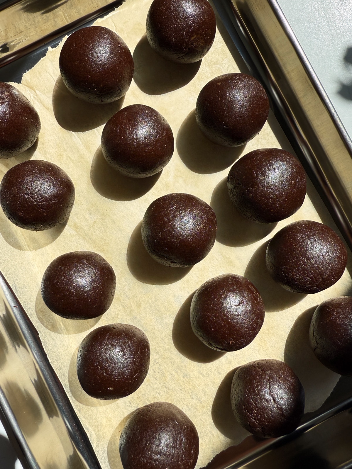 Mocha energy bites on lined baking sheet.