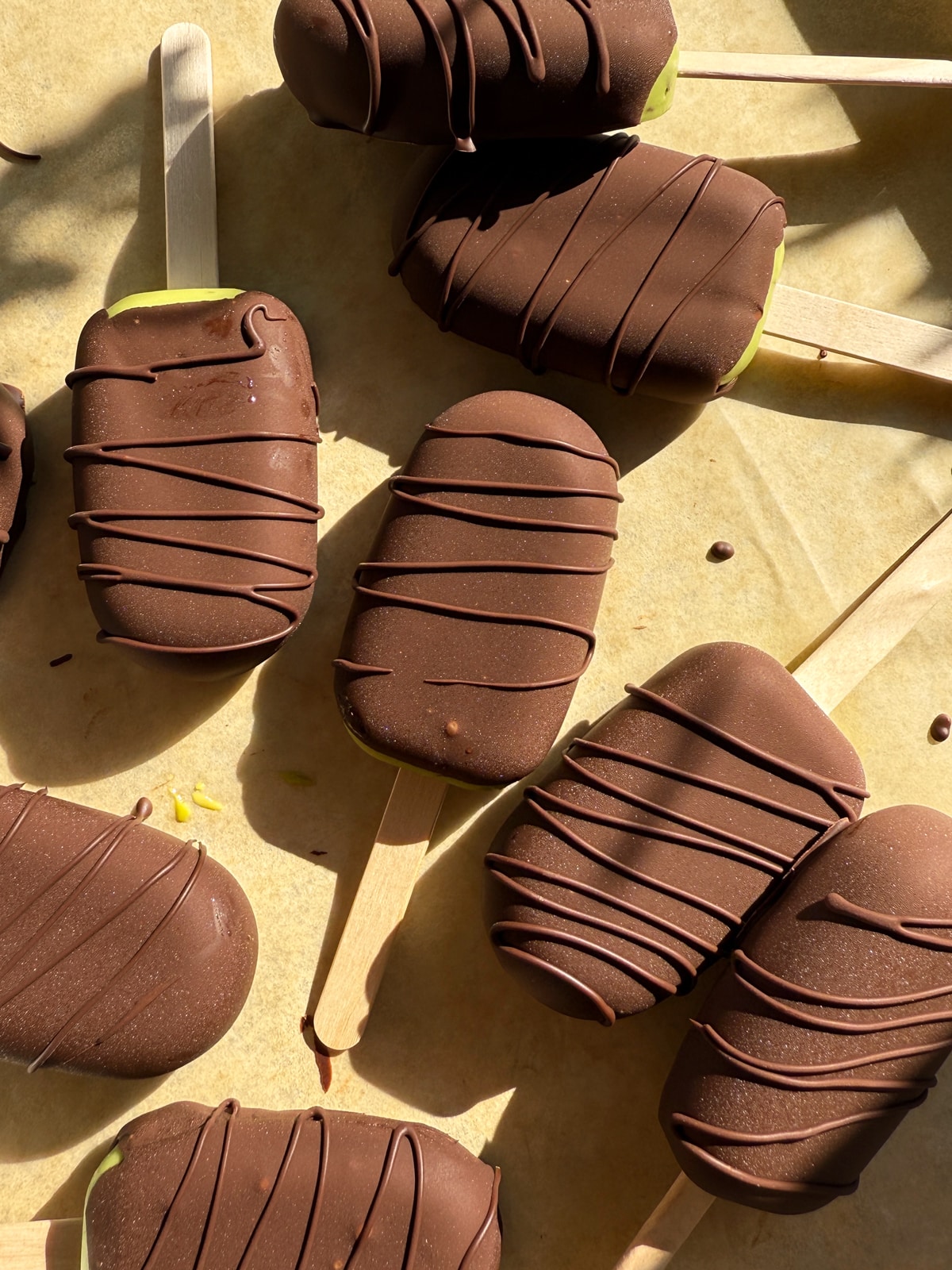 Ice cream bars on lined baking sheet.