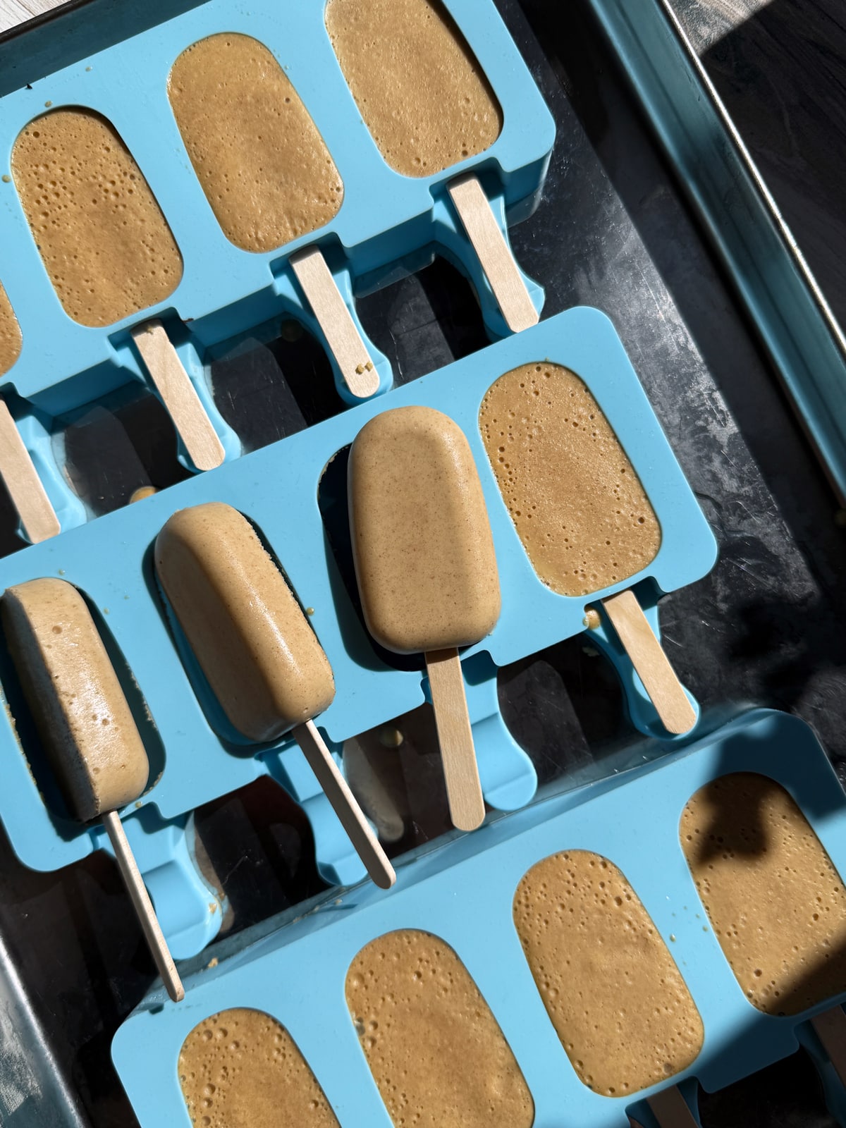 Frozen ice cream bars ready to dip in melted chocolate.