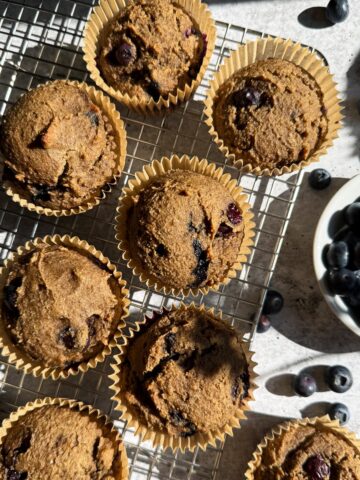 Vegan blueberry muffins on wire cooing rack.