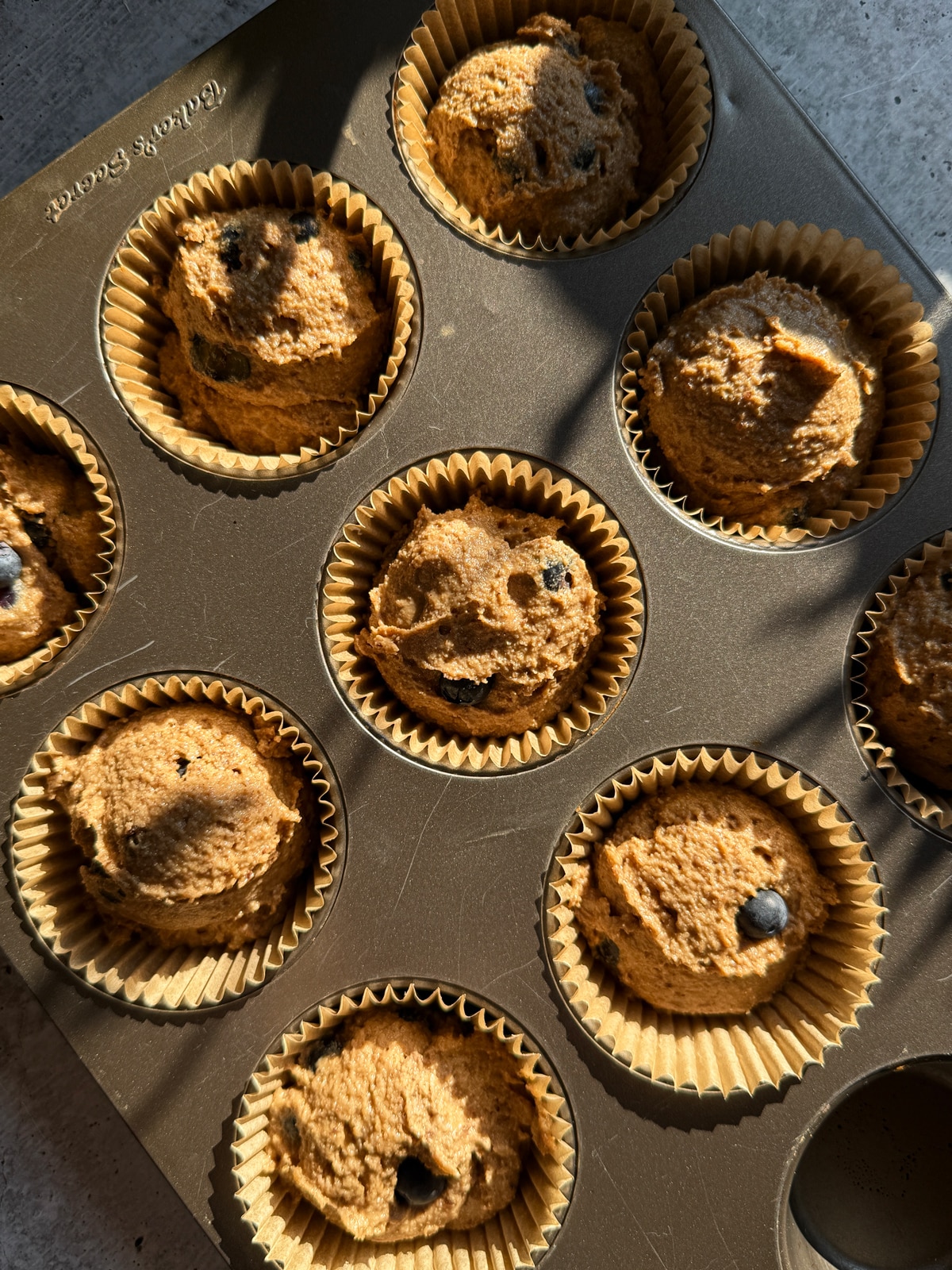 Unbaked batter in lined muffin tin.