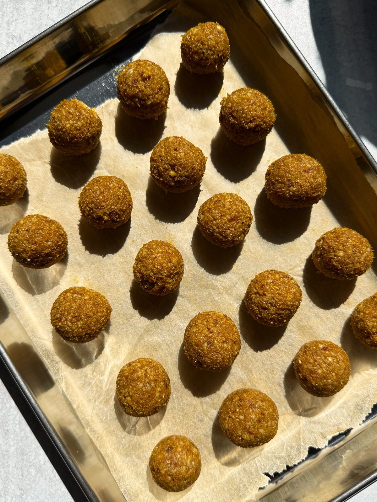 Filling mixture rolled into balls and placed on a lined baking sheet.