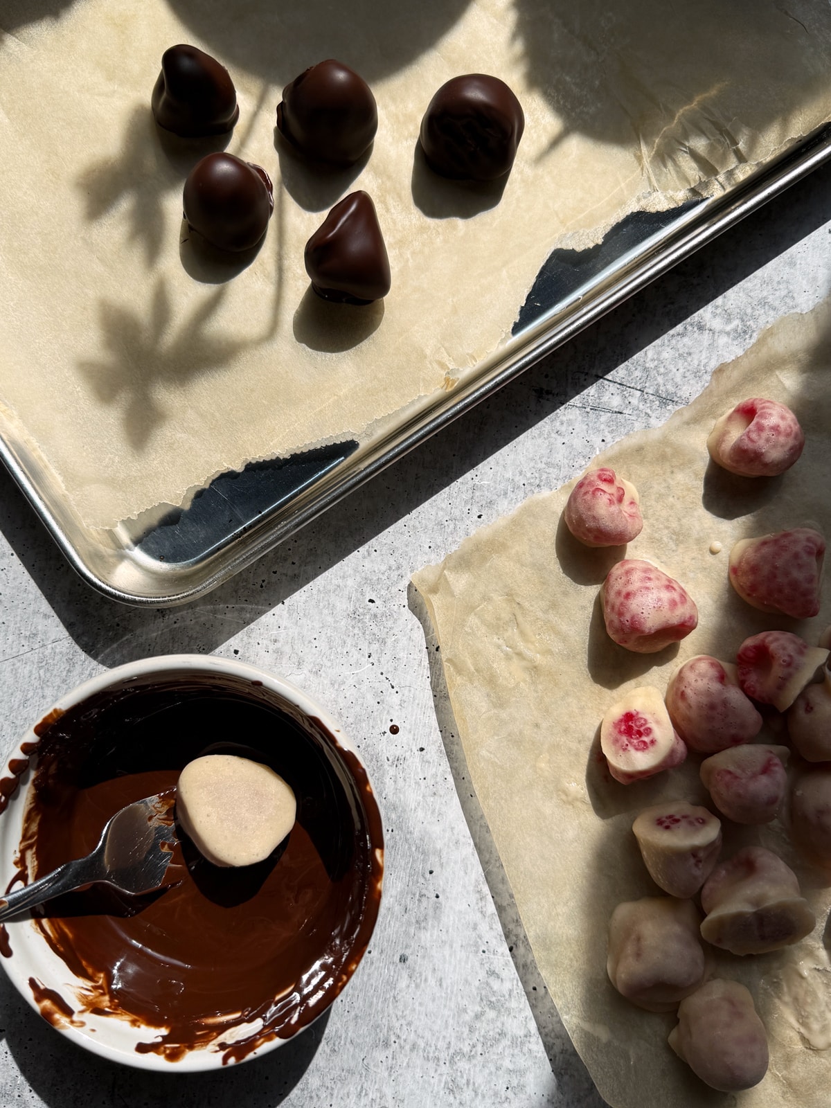 Dipping the yogurt raspberries in chocolate.