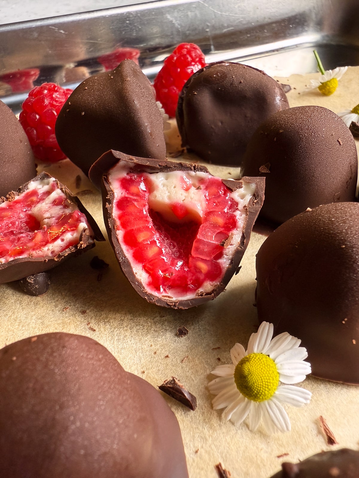 Close up of a chocolate raspberry cut in half.