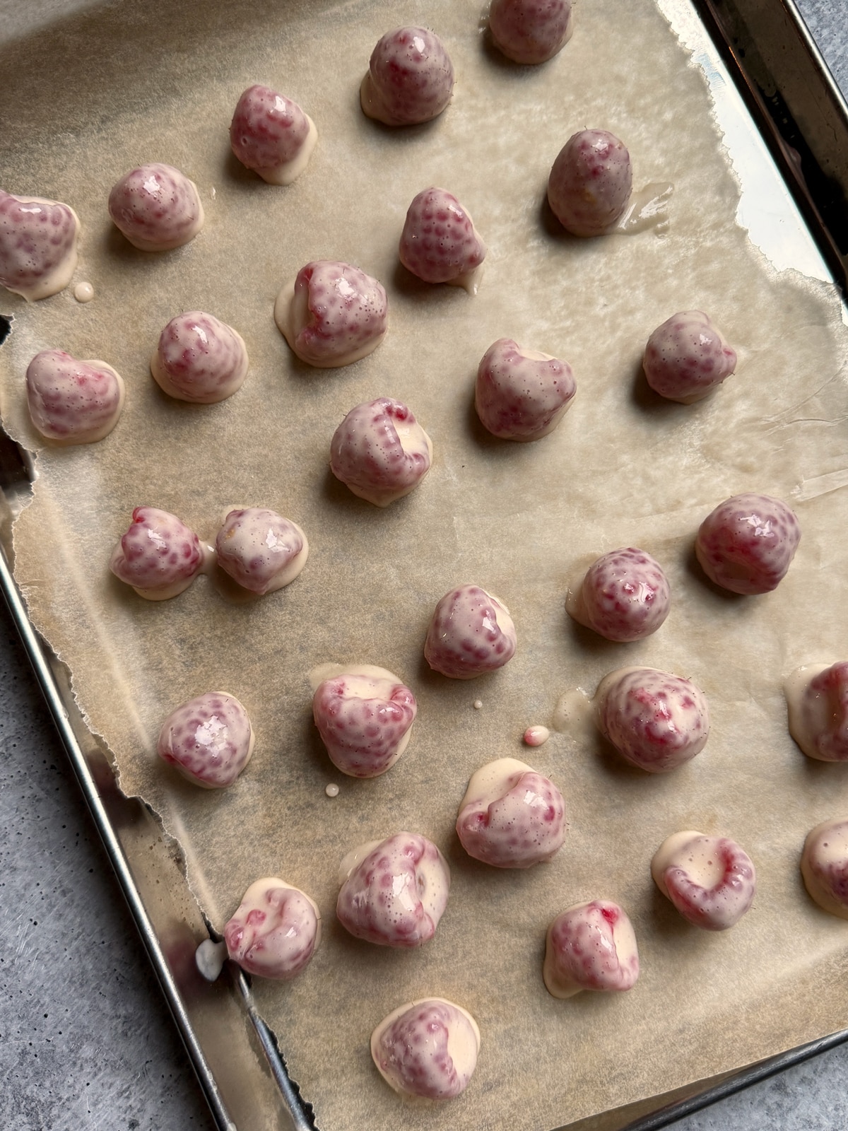 Raspberries dipped in yogurt and ready to freeze.