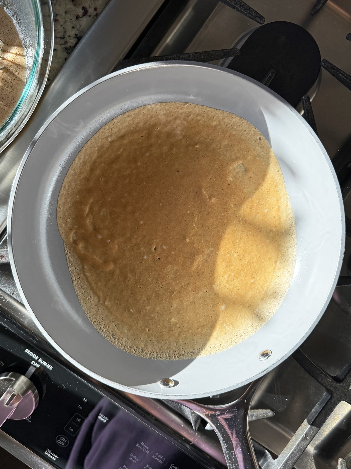 Cooking the crepes on a frying pan.