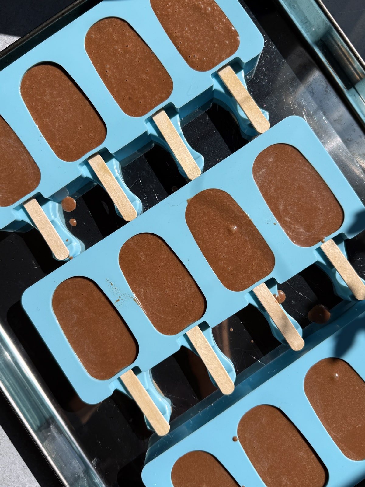 Ice cream bar filling in popsicle molds, ready to freeze.