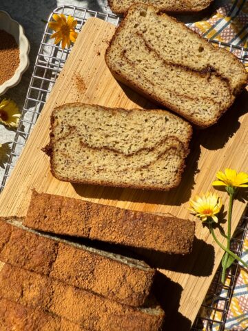 Slices of cinnamon swirl banana bread on cutting board.