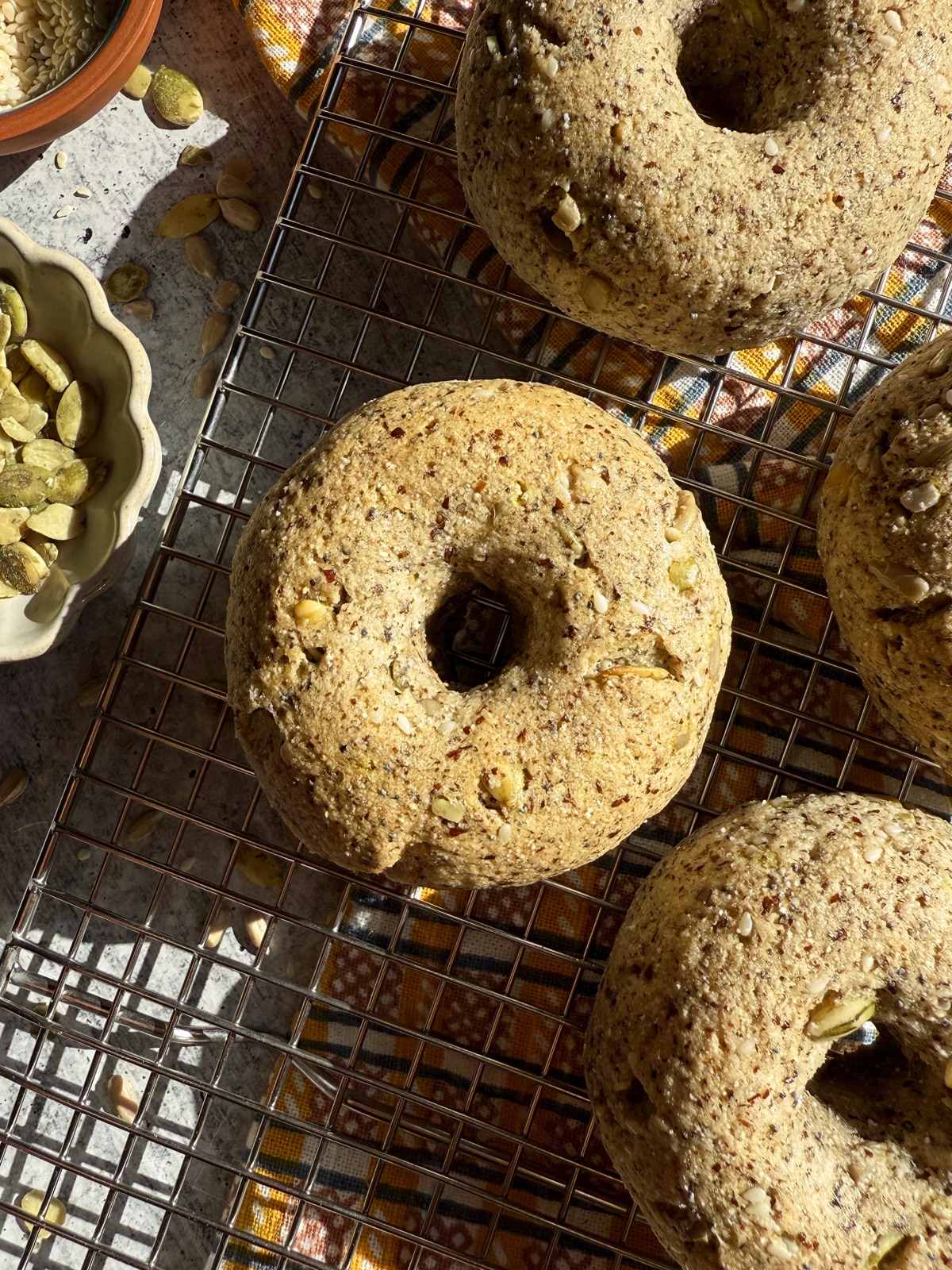 Healthy seed bagels on wire cooling rack.