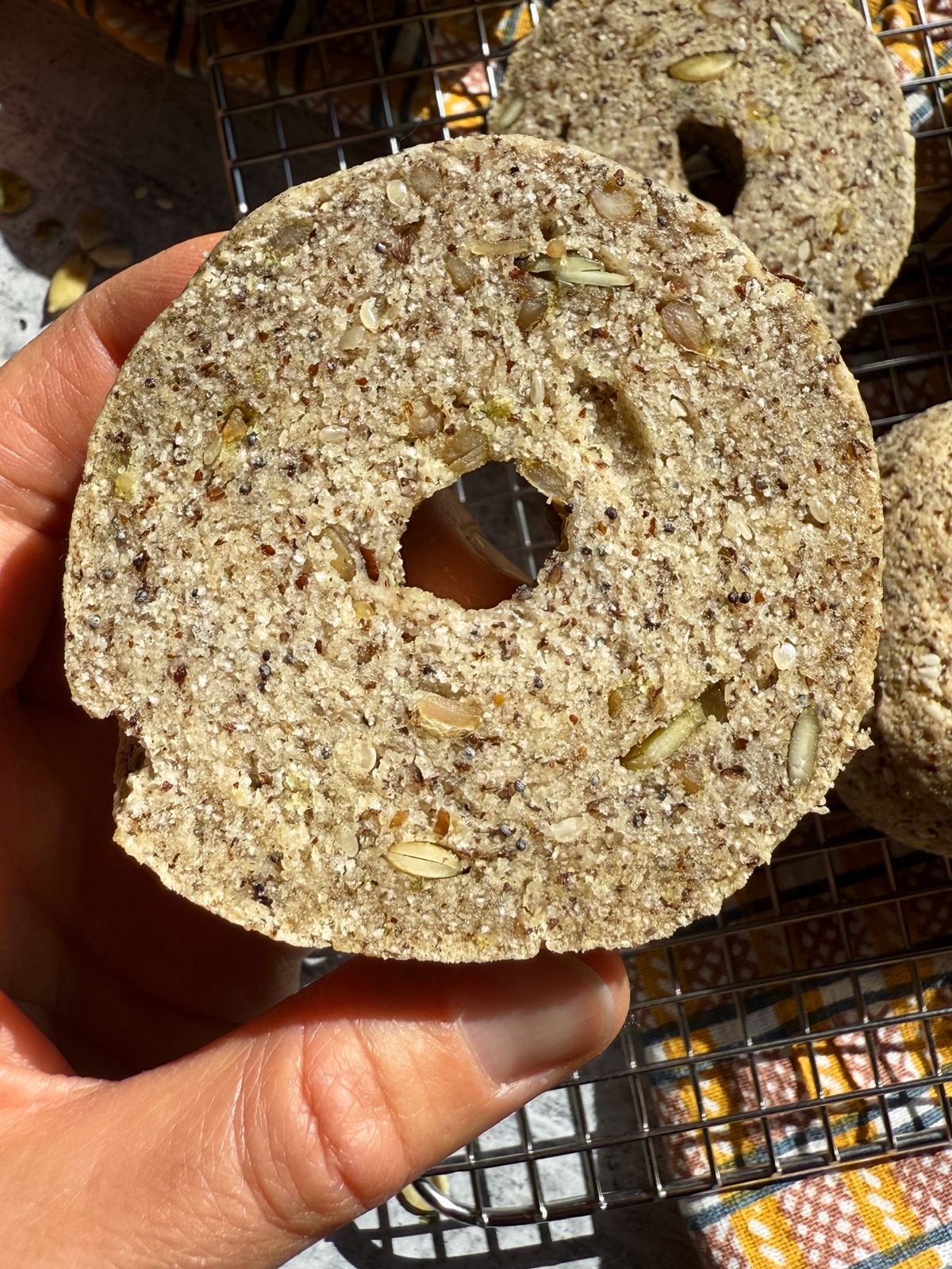 Holding a bagel cut in half.