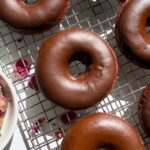 Top view of glazed donuts on wire cooling rack.